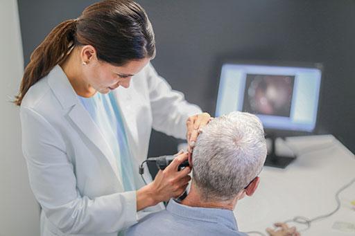 Hearing aid professional fitting a patient